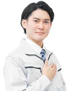 作業着を着た男性が笑顔で胸に手を当てています