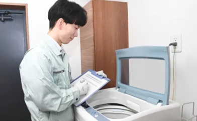 作業服を着た男性と洗濯機
