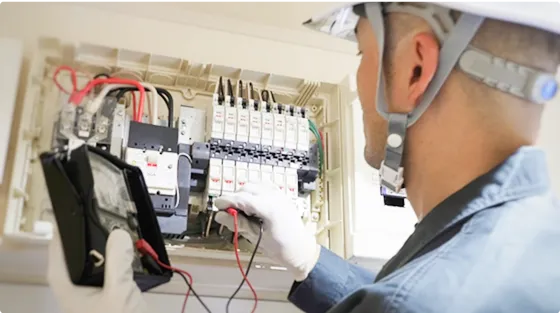 ブレーカー内を操作する作業服を着た男性